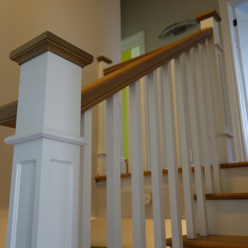 white fancy box newel posts with inlay and stained oak post cap, white square balusters and stained oak lambton profile handrail, install red oak treads on white risers