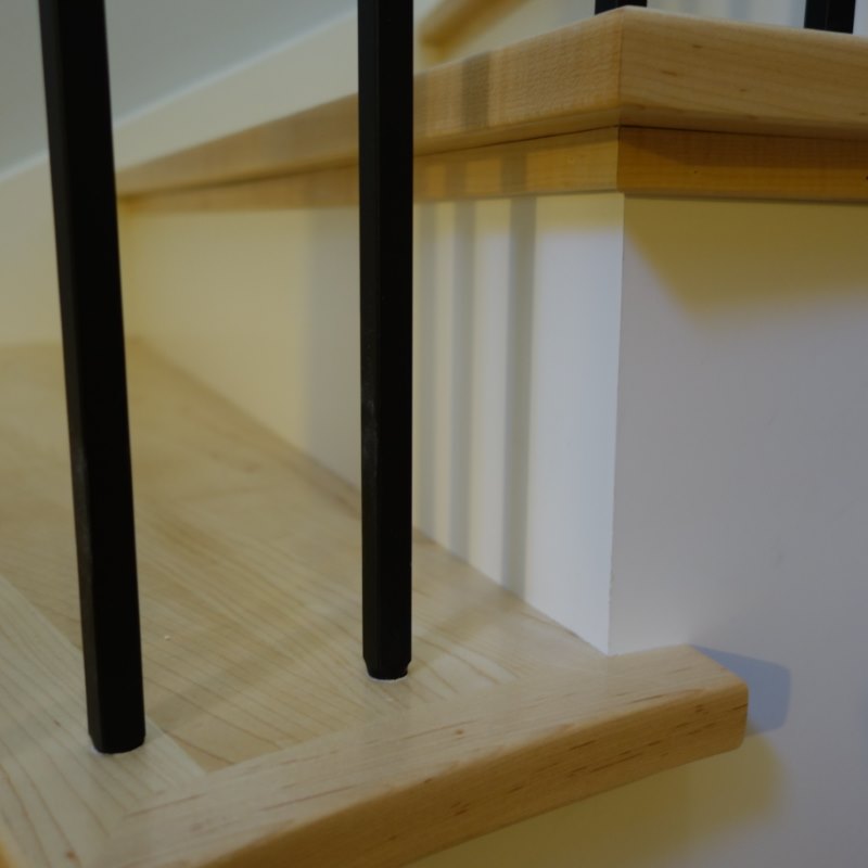 curved maple staircase, modern railing, black metal balusters