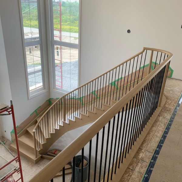 custom maple staircase ottawa stairbuilders with curved maple railing and black metal balusters