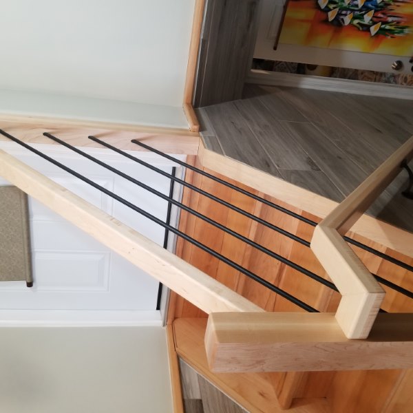 horizontal balustrade with black metal balusters and maple newel posts and handrail