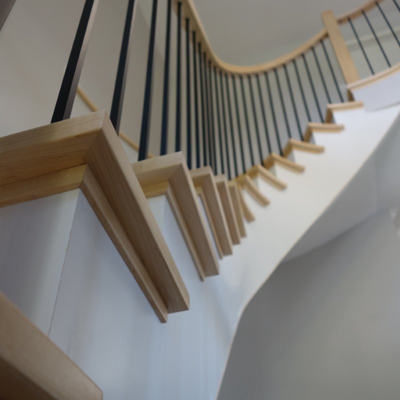 natural maple wood staircase with square treads, custom curved railing and stainless balusters